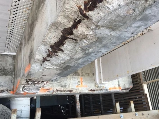 Figure 2. Corroded reinforcement and loss of concrete cover beneath reinforced concrete beams.