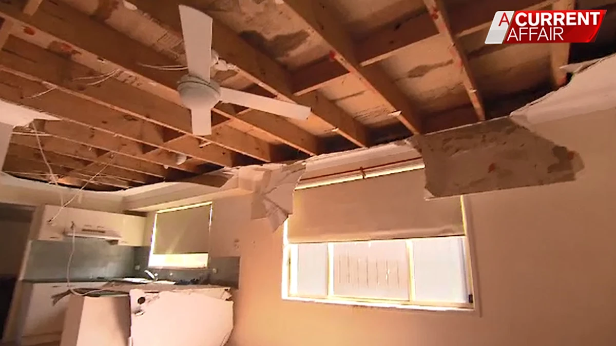 Damaged residential ceiling with exposed framing.